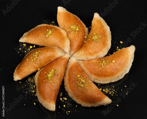 Qatayef, Traditional Arabic Ramadan Sweets with pistachio on black background photo