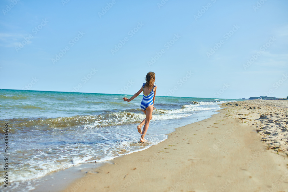 Happy, joyful little girl run on the beach Happy, joyful little girl run on the beach