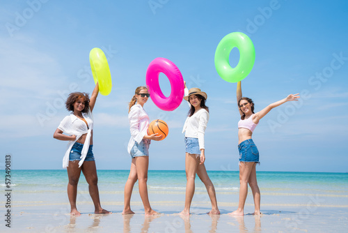 Group of teenage with floaty on the beach having fun in a sunny day, Summer group of friends at beach.