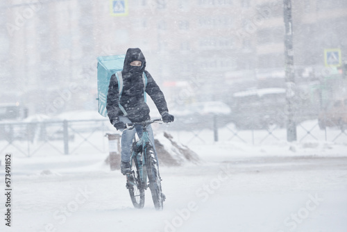 Wallpaper Mural a man on a bicycle in a snowstorm in the city the concept of a fast delivery service in any weather on time Torontodigital.ca