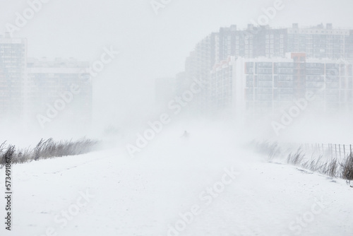 silhouette of a man walking in a snowstorm in the city the concept of a storm blizzard and bad weather.