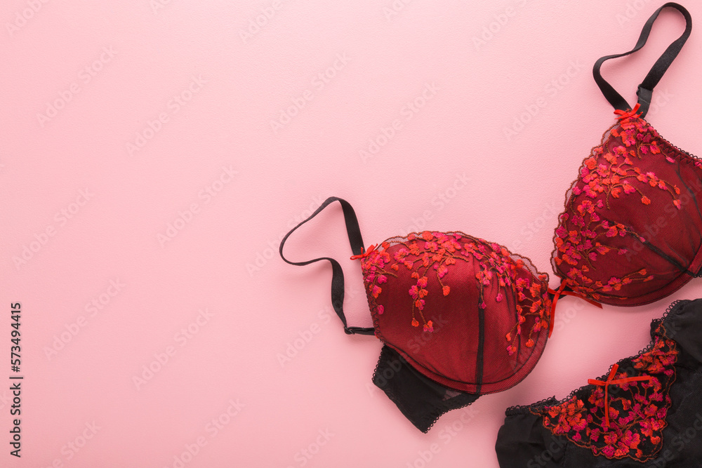 Female dark black red bra and panties on light pink table background.  Pastel color. Closeup. Woman underwear set. Romantic lingerie. Empty place  for text. Top down view. Photos | Adobe Stock