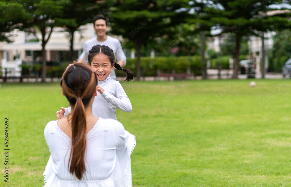 Portrait of enjoy happy love asian family father and mother holding hug cute little asian girl child smiling play and having fun moments good time in summer park at home Portrait of enjoy happy love asian family father and mother holding hug cute little asian girl child smiling play and having fun moments good time in summer park at home