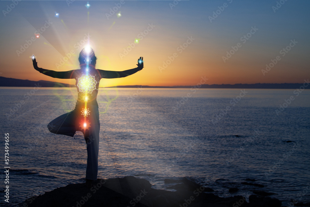 woman in yoga pose on beach sunset view, glowing seven all chakra. Kundalini energy. girl practicing meditation outdoors. Silhouette. - obrazy, fototapety, plakaty 