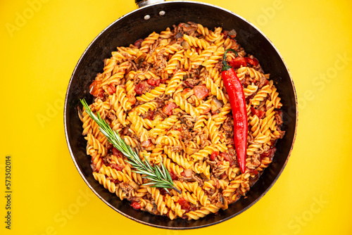 stewed pasta with meat in a frying pan