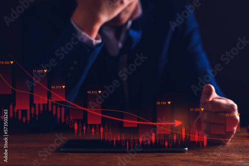 Property values ​​are steadily declining. Unhappy businessman, business downturn. company stocks fall in value, economic crisis, global economy slows down, trading drops, high risk investments. photo