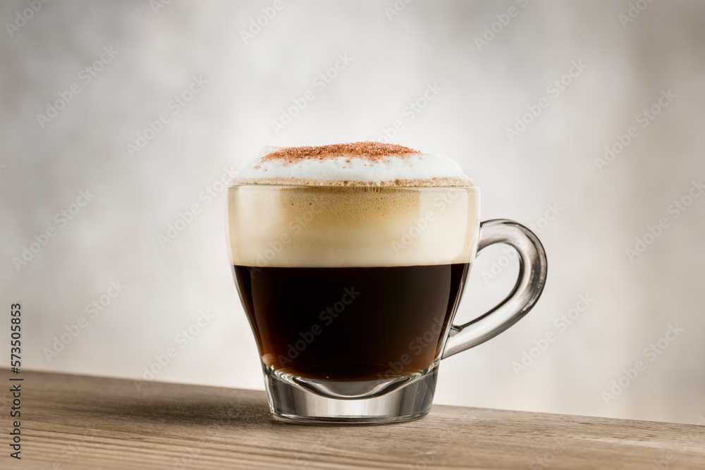 Cappuccino in glass cup on wooden table Cappuccino in glass cup on wooden table