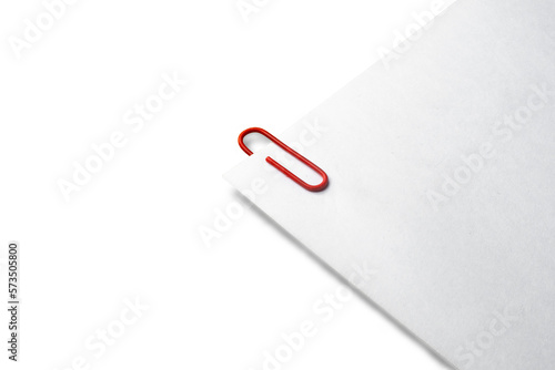 White sheets held together by a red paper clip with shading and lot of copy space