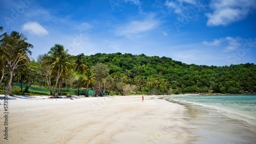 Phu Quoc island, Vietnam - March 31, 2019: White sand beach, calm sea. Rocky hills, growing palms and tropical trees. Beautiful coast of the South China Sea © KURLIN_CAfE