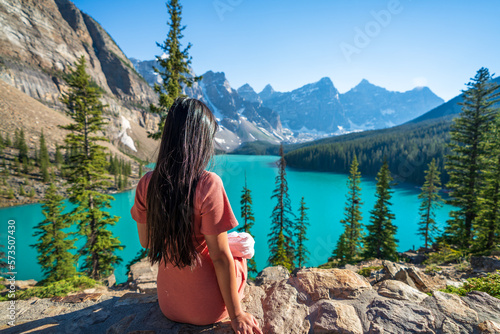 Young girl enjoying Moraine Lake beautiful scenery. Banff National Park nature landscape. Canadian Rockies summer time. Alberta, Canada.