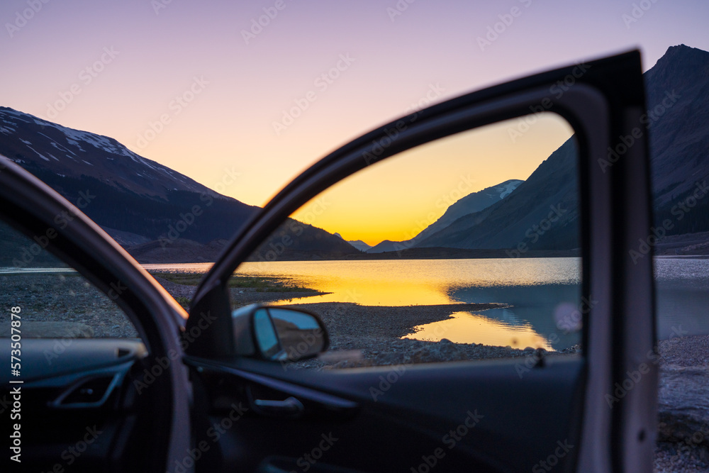 Naklejka premium Car parked on lake shore at twilight. Concept of travel, road trip.
