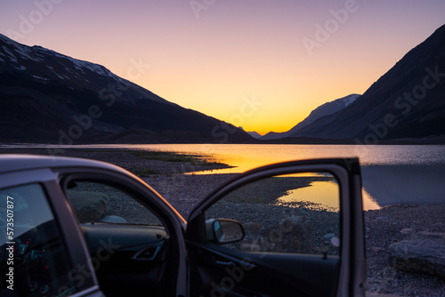 Car parked on lake shore at twilight. Concept of travel, road trip. © Shawn.ccf