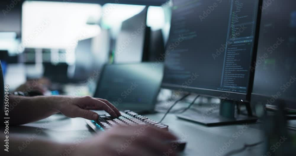 Close Up of a Software Developer Working on a Computer, Typing Programming Code on a Stylish Keyboard with Neon Backlight. Professional Employee Doing Work in a Cyber Security Technology Company