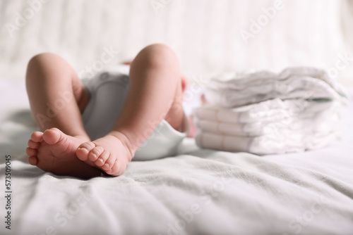 Little baby lying at bed, focus on legs