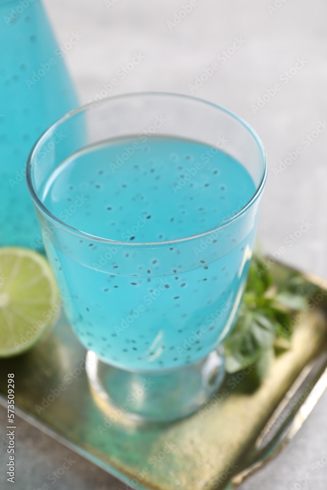 Tasty light blue drink with basil seeds on grey table Tasty light blue drink with basil seeds on grey table