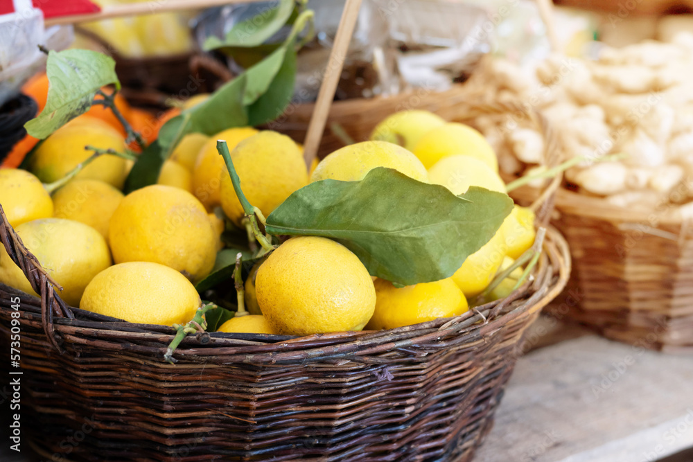 Basket with ripe lemons on the market, harvest of citrus fruits.