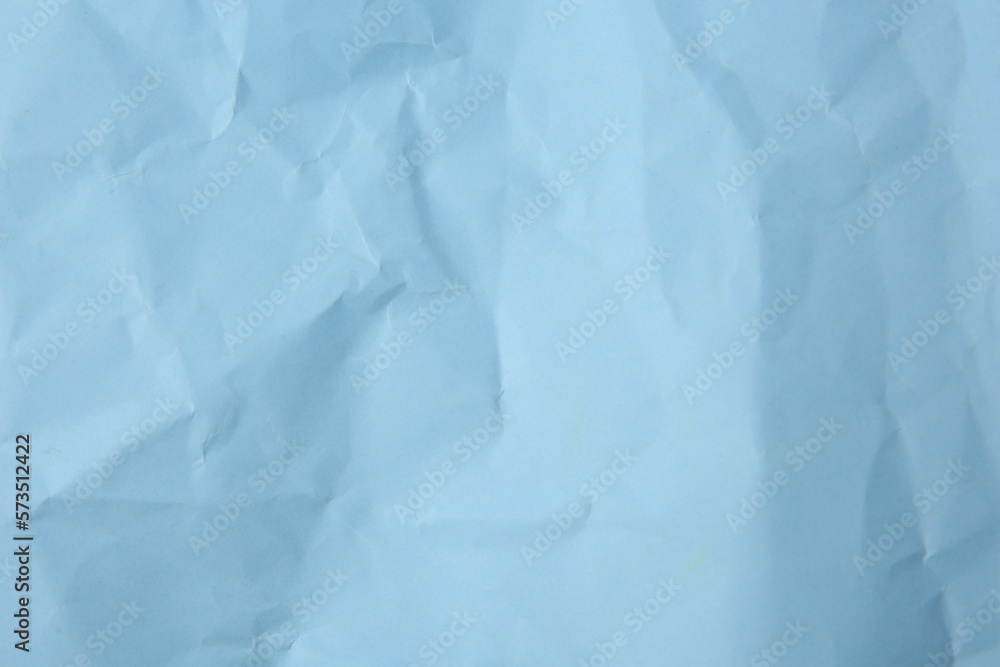 Fototapeta premium Sheet of crumpled light blue paper as background, top view