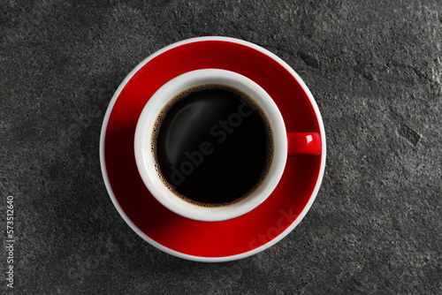 Cup with aromatic coffee on grey textured table, top view