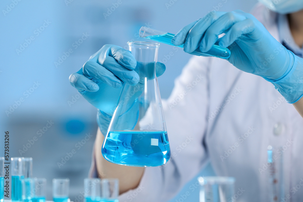 Scientist working with beaker and test tube in laboratory, closeup Scientist working with beaker and test tube in laboratory, closeup