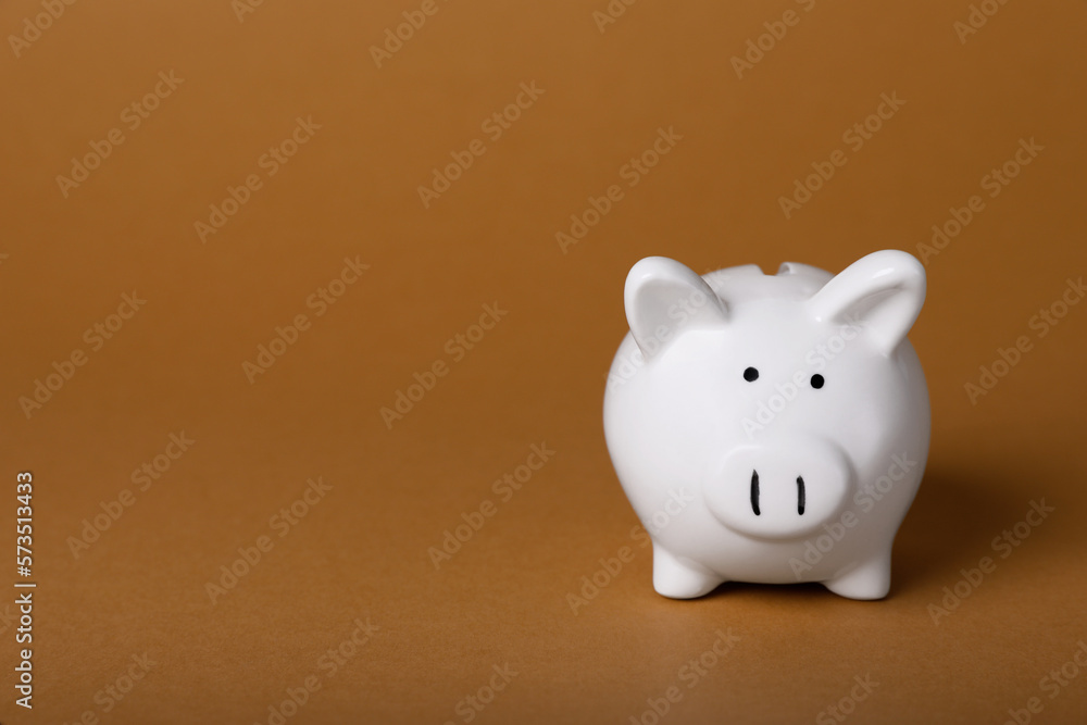 Ceramic piggy bank on brown background, space for text. Financial savings Ceramic piggy bank on brown background, space for text. Financial savings
