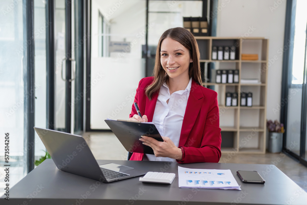 Marketing, Finance, Accounting, Planning, Team female accountant using laptop calculator and documents, charts, graphs in the analysis of the company is profit. Marketing, Finance, Accounting, Planning, Team female accountant using laptop calculator and documents, charts, graphs in the analysis of the company is profit.