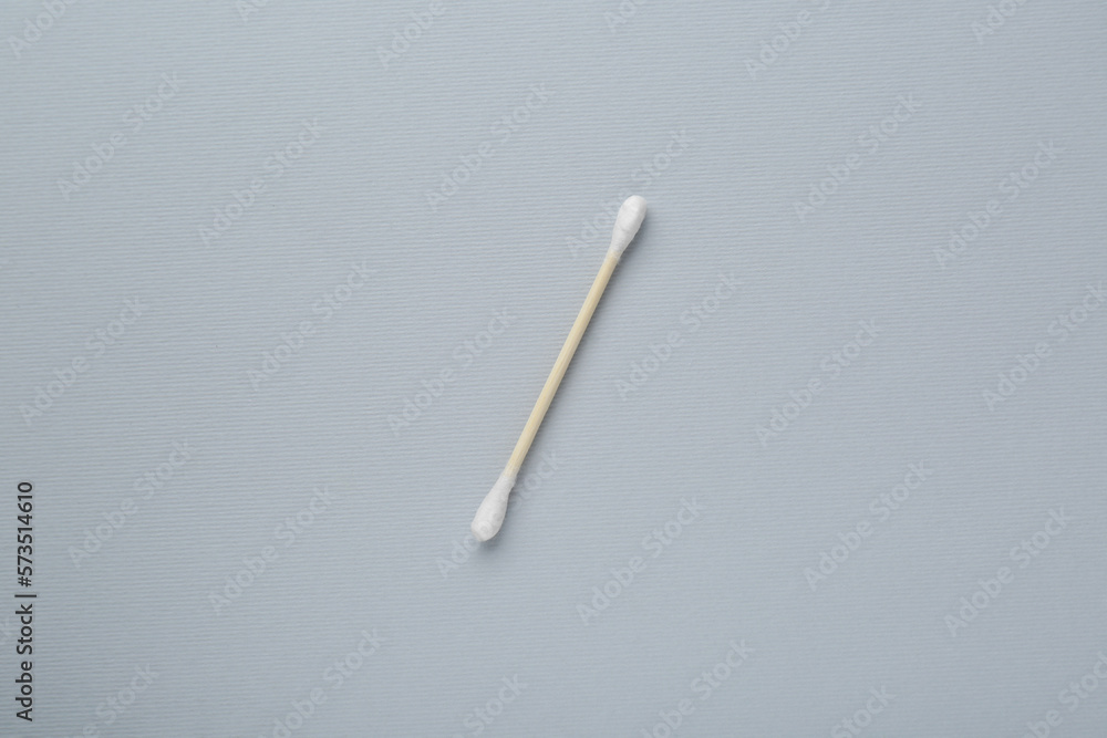 One wooden cotton bud on light grey background, top view One wooden cotton bud on light grey background, top view