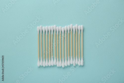 Many wooden cotton buds on turquoise background  flat lay