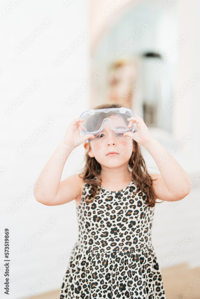 portrait of a little girl wearing safety goggles for science class in school portrait of a little girl wearing safety goggles for science class in school