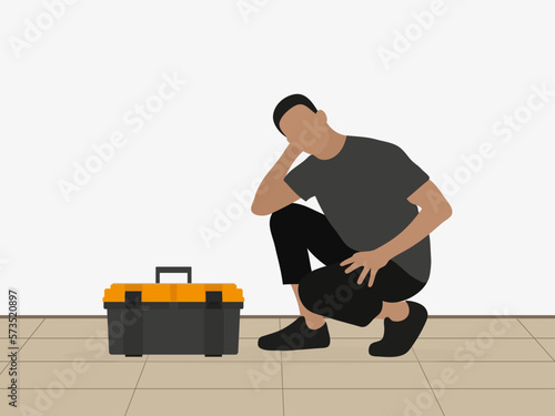 Thoughtful man squatting near toolbox indoors