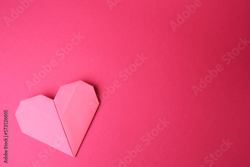 Paper heart on pink background, top view and space for text. Origami art