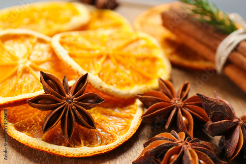 Dry orange slices and anise stars on wooden board, closeup