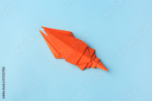 Origami art. Handmade orange paper crayfish on light blue background  top view