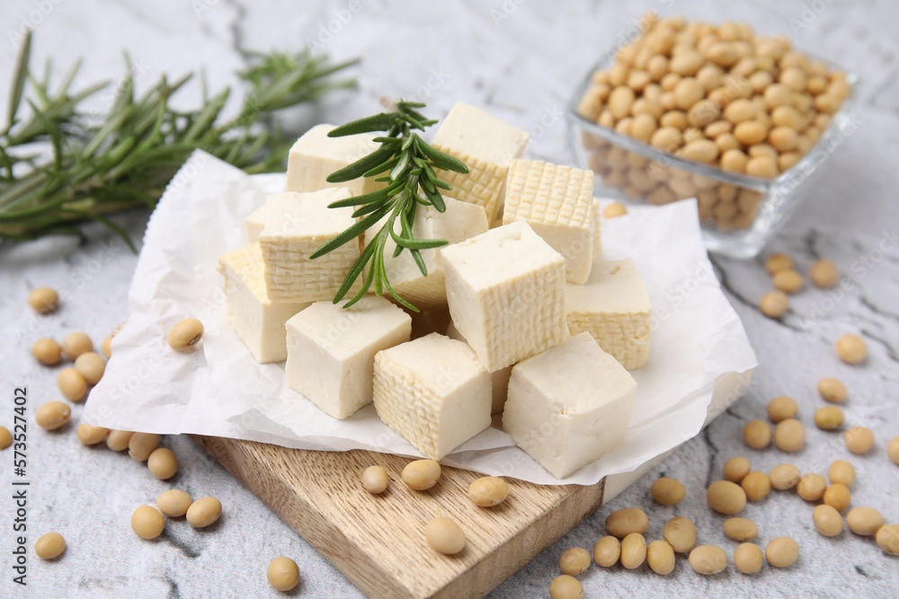 Delicious tofu cheese, rosemary and soybeans on light gray textured table, closeup