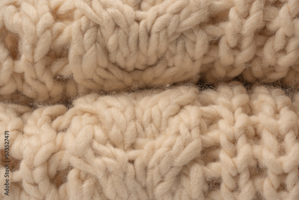 A fragment of beige knitted fabric, knitted from white sheep wool. A fragment of beige knitted fabric, knitted from white sheep wool.