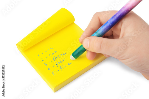 Child erasing word Five written with erasable pen on sticky note against white background, closeup