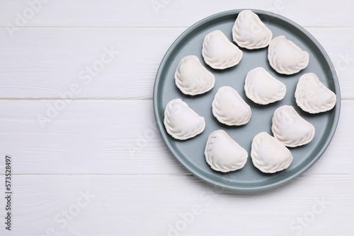 Raw dumplings (varenyky) on white wooden table, top view. Space for text