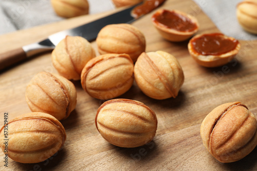 Homemade walnut shaped cookies with boiled condensed milk on wooden board, closeup