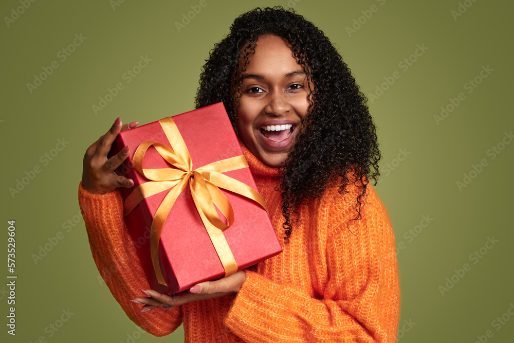 Smiling ethnic woman with present in studio Smiling ethnic woman with present in studio