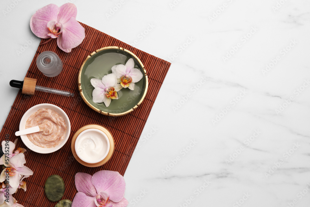 Composition with different spa products and flowers on white marble table, top view. Space for text Composition with different spa products and flowers on white marble table, top view. Space for text