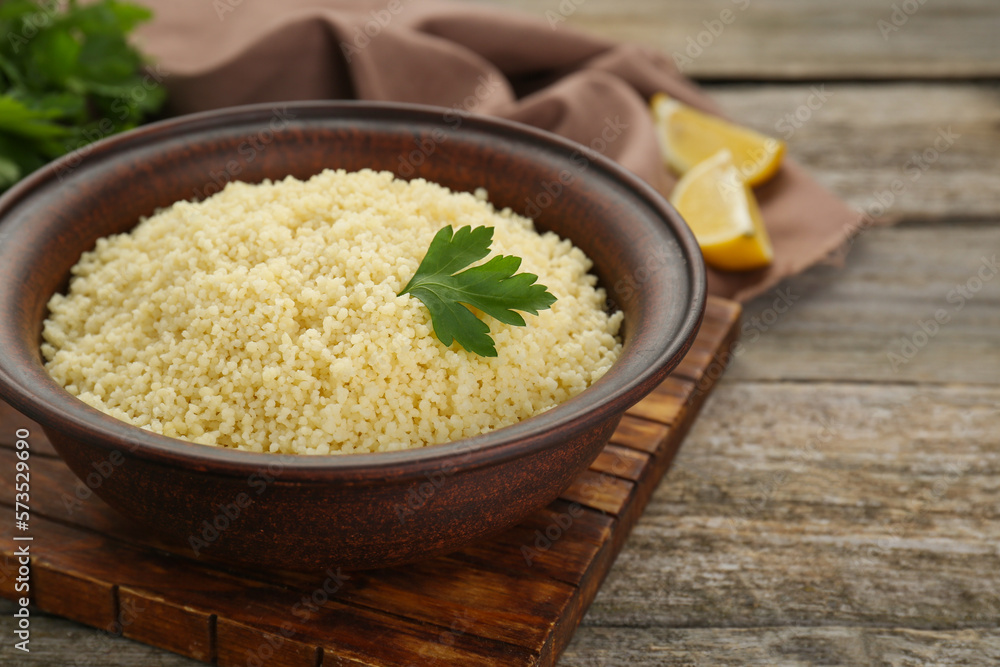 Tasty couscous with parsley on wooden table, closeup Tasty couscous with parsley on wooden table, closeup