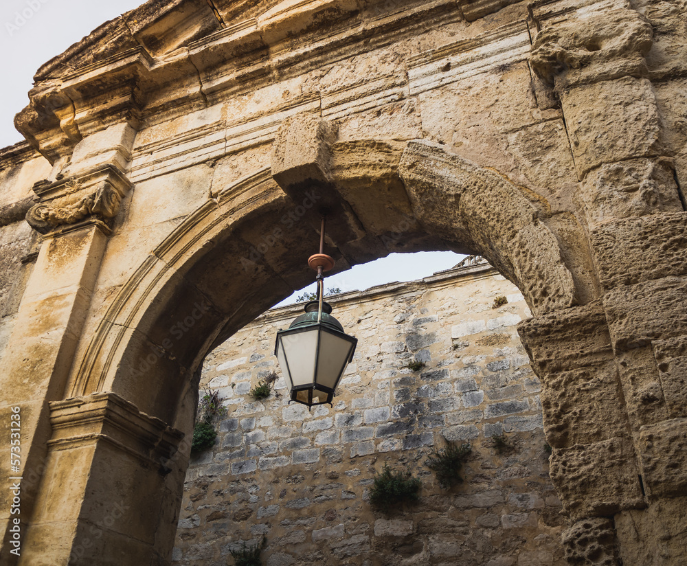Historic stone triumphal arch. Entrance to the castle with an antique lamp