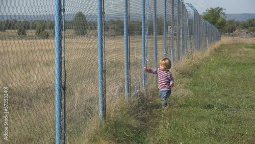 Photos Little child push a big fence, toddler break bounders