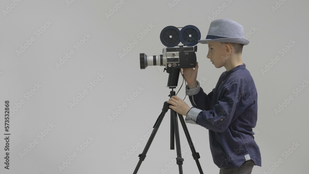 Young stage director filming with video camera in studio, future cinematography