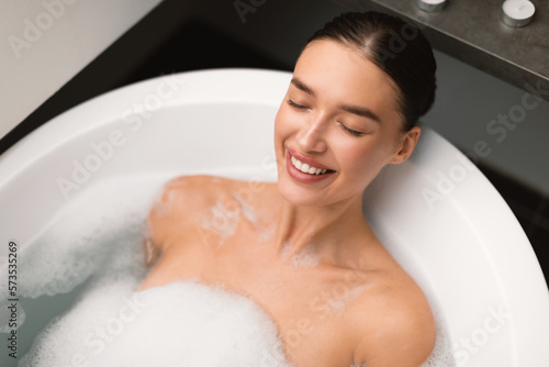 Happy Lady Taking Relaxing Bath With Foam In Modern Bathroom