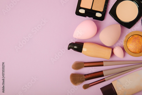 Beauty blender for applying bb cream or concealer and cosmetics on a bright colored background. Foundation, face powder, eye shadow, blush and lash mascara. Beauty concept. Fashion. Place for text.