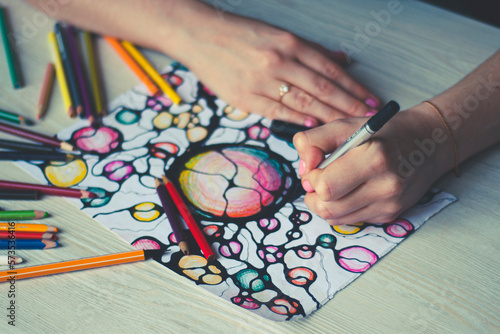 A woman draws neurographics, close-up. Abstract neurographic drawing with a marker, colored pencils. neurographic concept.