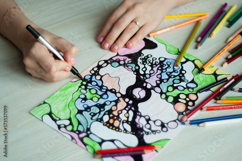 Close-up of female hands drawing neurographic art. Mental health, adult fine motor skills, creativity, psychology.