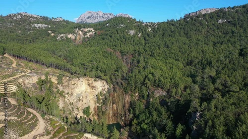 A beautiful wild waterfall in a forest thicket against the backdrop of mountains, on the southern coast of Turkey.