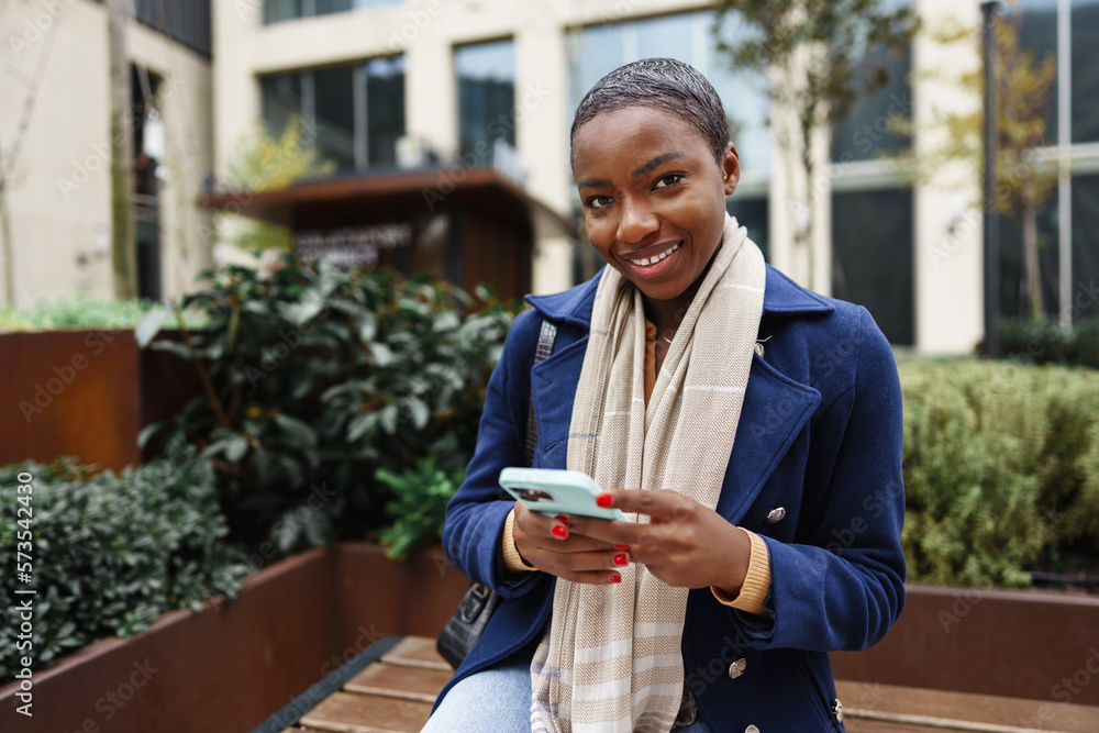 Portrait of beautiful young african woman using her mobile phone in the street Portrait of beautiful young african woman using her mobile phone in the street