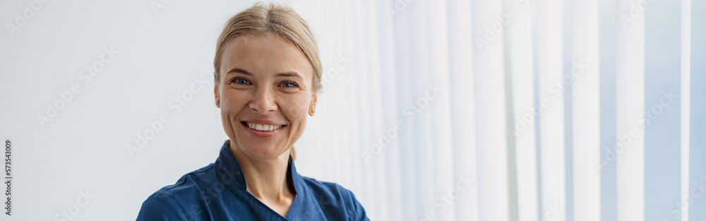 Portrait of female doctor in uniform standing in medicine clinic hall and looking camera Portrait of female doctor in uniform standing in medicine clinic hall and looking camera